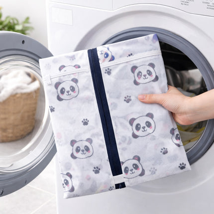 Person holding a panda-patterned mesh laundry bag in front of a washing machine.