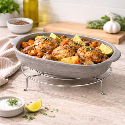 Baked chicken dish with vegetables in a gray baking dish on a wooden table.