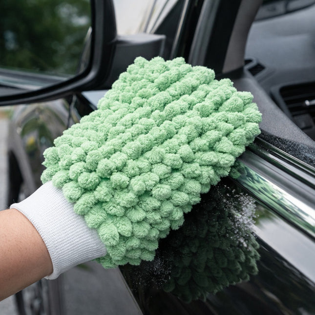 Green microfiber cleaning glove being used on a car window
