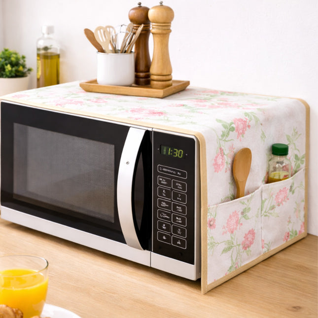 Floral-patterned microwave cover with a microwave and kitchen items on a wooden surface.