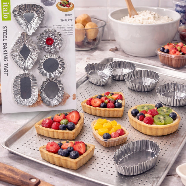 Metal tartlet tins with baking tray and filled tarts on a kitchen counter.