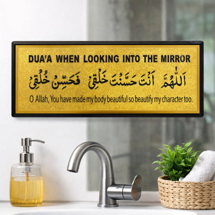 Decorative sign with Arabic text above a sink with soap dispenser and plant.