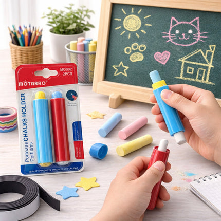 Colorful chalks with a holder and packaging on a table with a child's drawing in the background.