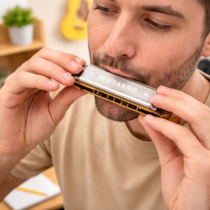 Man playing a Motarro harmonica with a casual setting in the background