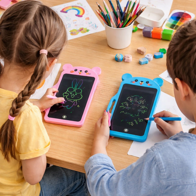 Two children using small electronic doodle boards on a table with coloring supplies.
