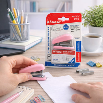 Pink stapler with Motarro packaging on a desk with stationery items.
