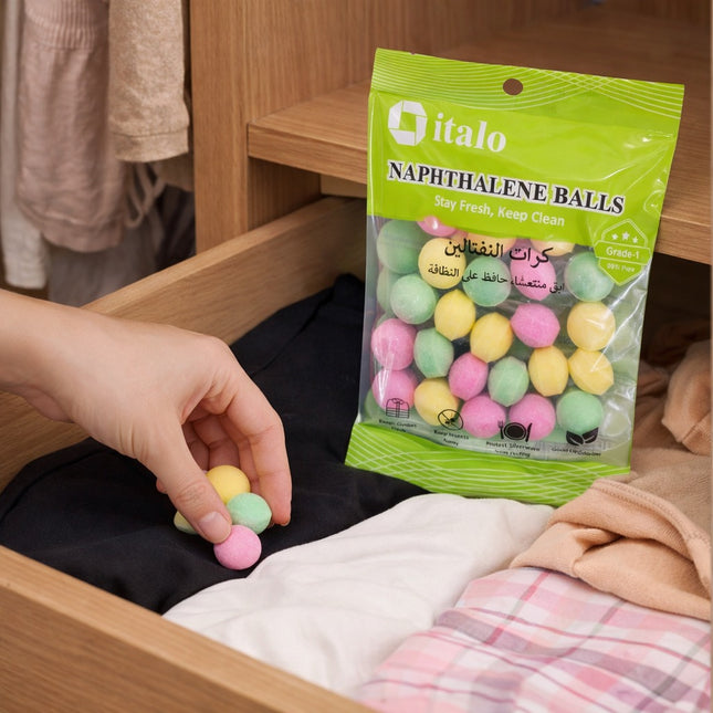 Person holding a colorful naphthalene ball next to a green 'italo' package of naphthalene balls.