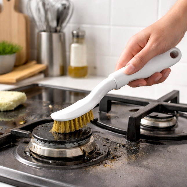 Person cleaning a stove burner with a scrubbing brush