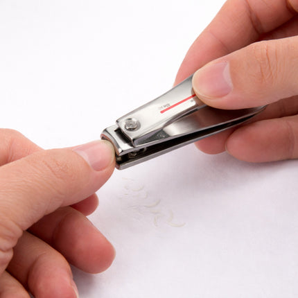 Person using a nail clipper on a white background