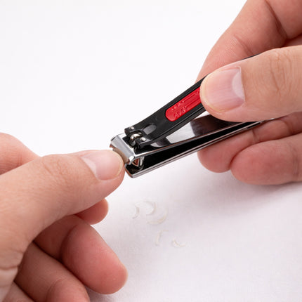 Nail clipper being used on a white background
