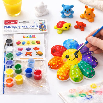 Colorful painted vinyl doll kit with paint supplies and a hand holding a brush.