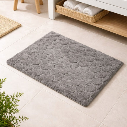 Gray textured rug on a light wooden floor with a plant and basket in the background