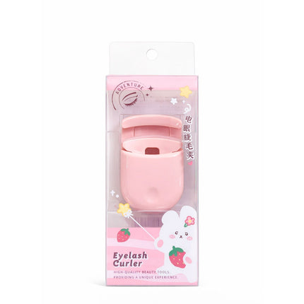 Pink eyelash curler in its packaging on a white background