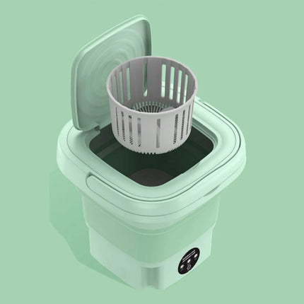 Small washing machine with a basket on a light green background