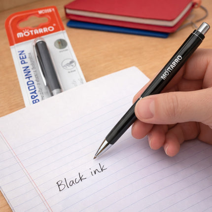 Person writing on a notebook with a Motaro pen, showing black ink being used.