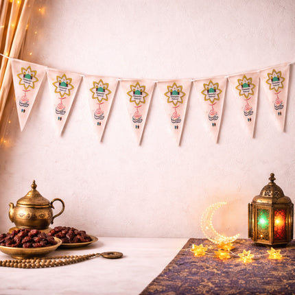 Decorative setup with lantern, teapot, dates, and bunting on a light background