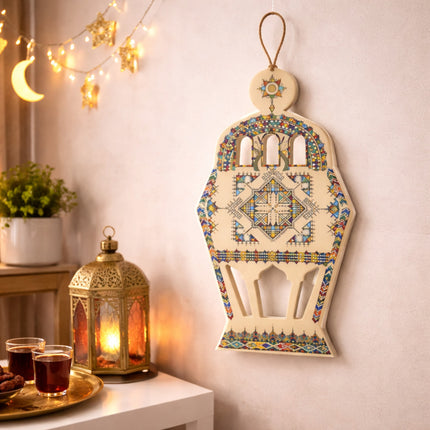 Decorative Hamsa wall hanging with a lantern and tea on a table in the background.