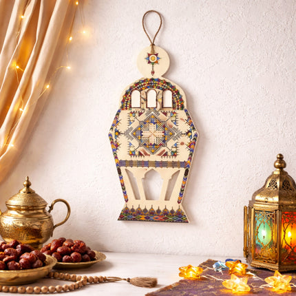 Decorative lantern with intricate patterns, dates, and a lit lantern on a white background