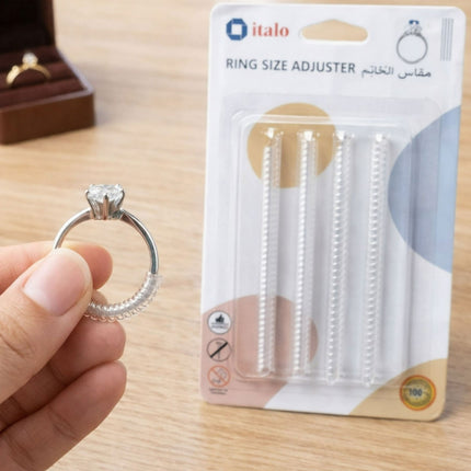 Hand holding a silver ring with a 'italo' ring size adjuster in the background