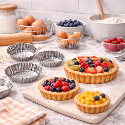 Fruit tarts on a kitchen counter with baking ingredients and utensils.