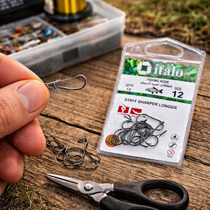 Fishing hooks with a package labeled 'O'italo' on a wooden surface.