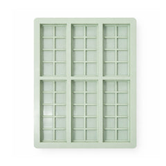 Light green silicone ice cube tray with grid pattern on a white background