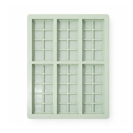 Light green silicone ice cube tray with grid pattern on a white background