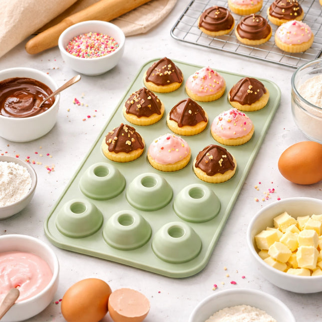 Green silicone donut mold with mini donuts on a white surface with baking ingredients.