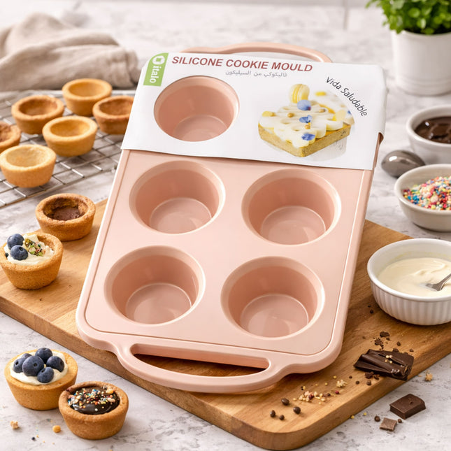 Silicone cookie mould on a wooden board with baking ingredients in the background