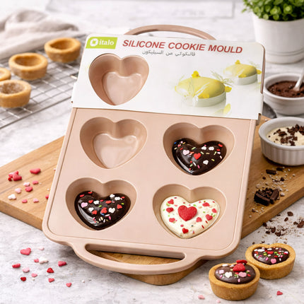 Silicone cookie mould with heart shapes on a wooden board, surrounded by decorated cookies and baking ingredients.