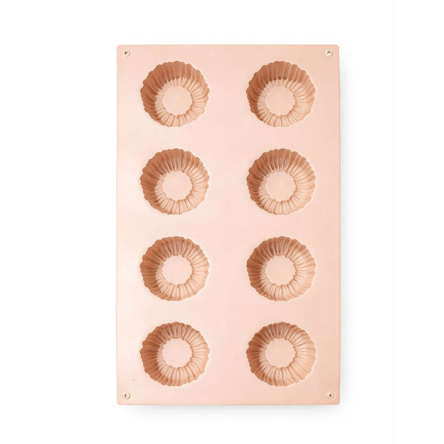 Pink silicone mold with circular shapes on a white background