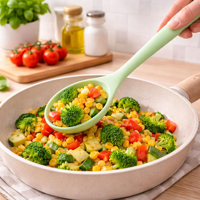 Vegetable stir-fry in a pan with a green spoon, set on a kitchen counter.