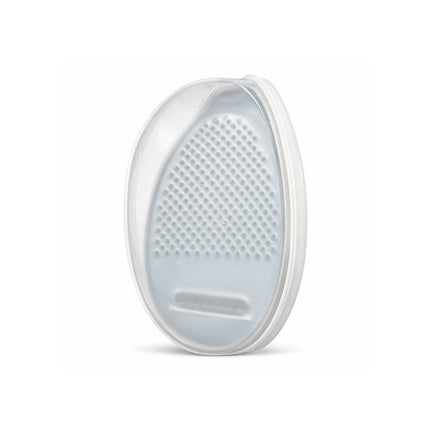 Round white grooming tool with textured surface on a white background