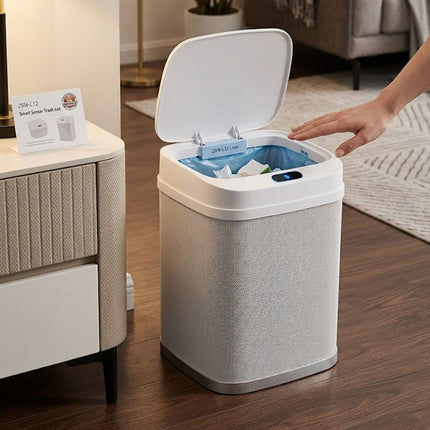 Smart trash can with a hand reaching in to open the lid in a home setting.