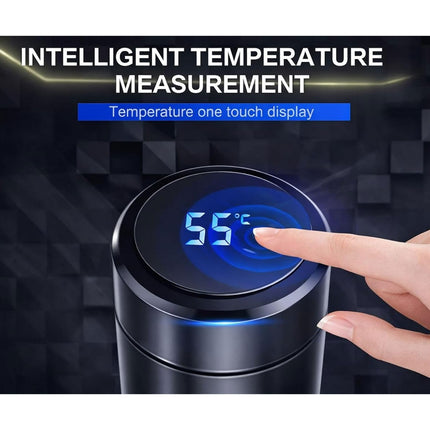 Digital temperature display with a finger touching it, set against a dark geometric pattern background.