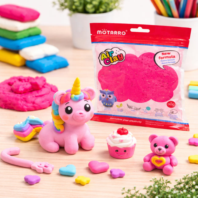 Pink unicorn figurine, cupcake, and bear with Motarro Air Clay packaging on a wooden surface.