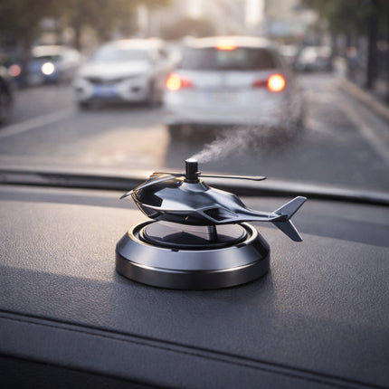 Helicopter-shaped car air freshener on a car dashboard with traffic in the background