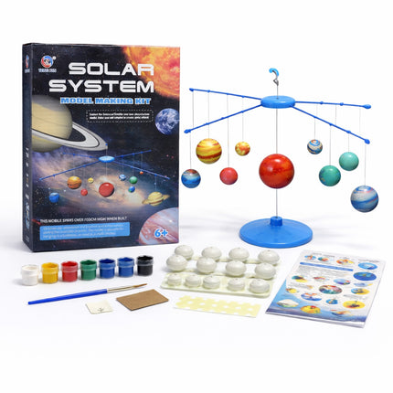 Solar system model making kit with packaging, planets, and tools on a white background