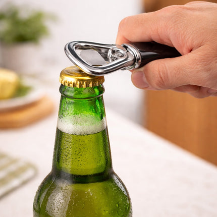 Hand using a bottle opener on a green beer bottle with a blurred background