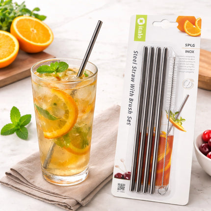 Glass of iced tea with oranges and a package of steel straws on a table.