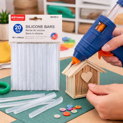 Silicone bars packaging with a hot glue gun applying glue to a wooden craft project.
