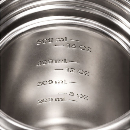 Close-up of a metal container with measurement markings in milliliters and ounces.