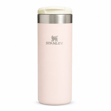 A light pink Stanley travel tumbler with a stainless steel band and a cream-colored flip-top lid, shown on a plain white background.