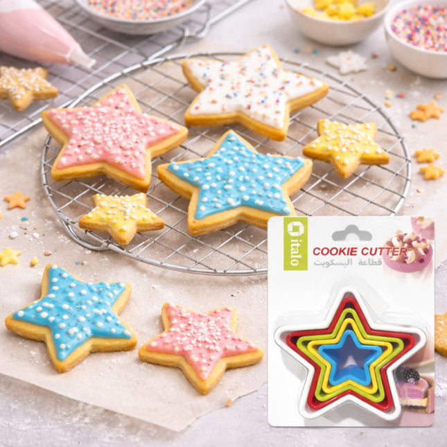 Star-shaped cookies with colorful icing on a cooling rack, next to a star-shaped cookie cutter set.