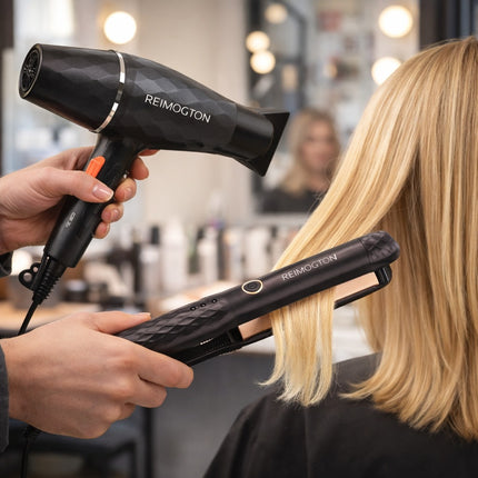 Person using a REIMOQTON hair dryer and straightener on a customer's hair in a salon setting.