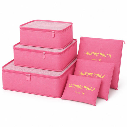 A set of pink fabric travel organizers and laundry pouches with gold printed text, shown on a clean white background. The set includes three rectangular zippered boxes, two flat zippered pouches, and one small flat pouch, all in matching pink fabric with gold lettering.