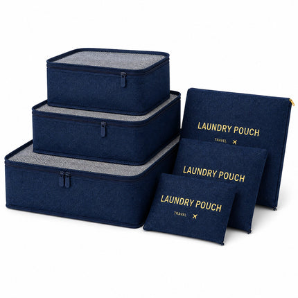 A set of navy blue fabric travel organizers and pouches with gray interior lining and gold text, arranged on a clean white background.