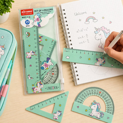 Set of unicorn-themed rulers and protractors on a table with a notebook.