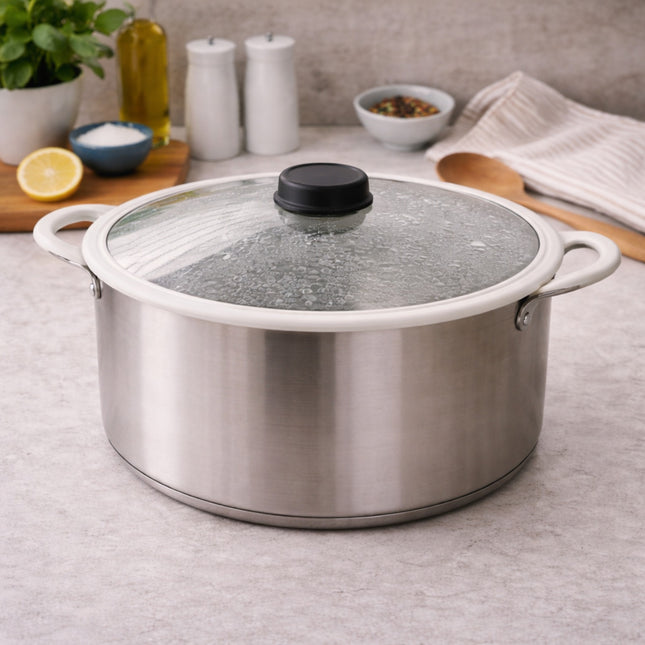 Stainless steel pot with glass lid on a kitchen counter