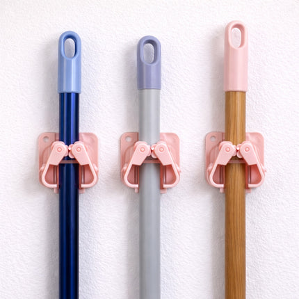 Three brooms with blue, gray, and wooden handles, each held by a pink holder against a white background.